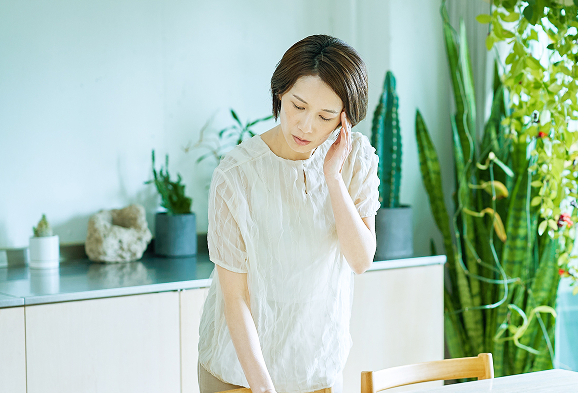 頭に手を添える女性のイメージ